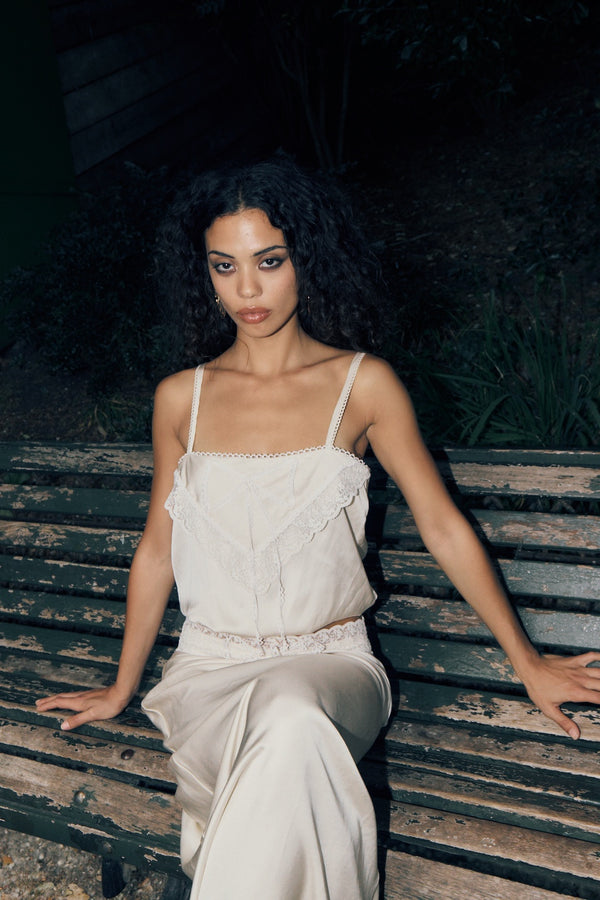 woman wearing off-white 2 piece long skirt and top.