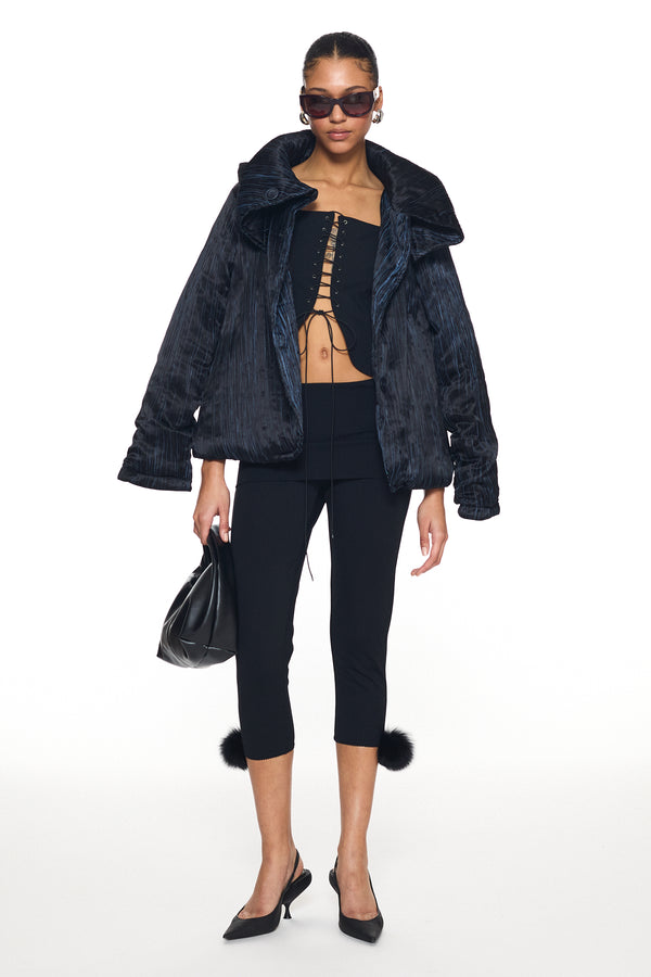 Woman wearing black textured jacket and corset-style top